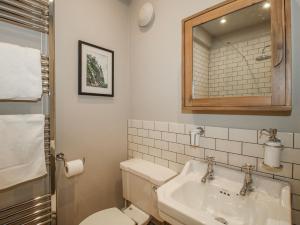 a bathroom with a sink and a toilet and a mirror at The Old China Shop in Ludlow +21 photos