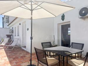 a table and chairs with an umbrella on a patio at Hacienda Gallego in Málaga +42 photos