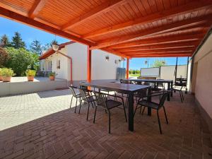 a patio with tables and chairs under a wooden pergola at Csenár Apartman Hegykő in Hegykő