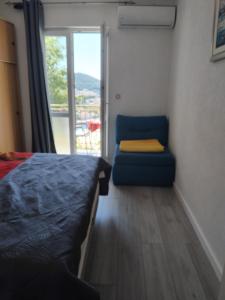 a bedroom with a bed and a chair and a window at Pansion Panorama Dubrovnik's Most Beatiful Sea View in Dubrovnik