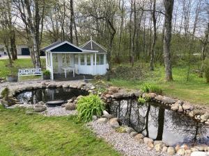 a gazebo with a pond in a yard at Private country side apartment in Holstebro