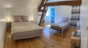 a bedroom with a bed and a chair in it at L'Auberge de Reullée in Marigny-lès-Reullée