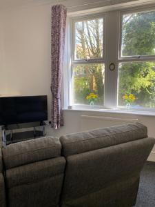 a living room with a couch and two windows at The Snug on Hornby in Morecambe