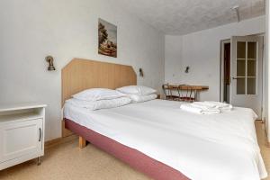a bedroom with a large white bed and a table at Velga in Vilnius