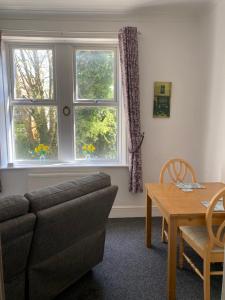 a living room with a couch and a table and a window at The Snug on Hornby in Morecambe