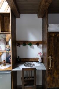 a small kitchen with a table and a stool at Casa Róza Vendégház in Sfântu-Gheorghe