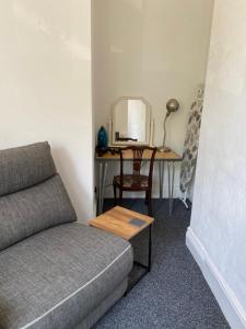 a room with a couch and a desk with a mirror at The Snug on Hornby in Morecambe