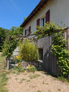 a house with a fence and flowers in front of it at instant de tranquillité en Cévennes in Aujac