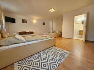a bedroom with two beds and a living room at Csenár Apartman Hegykő in Hegykő