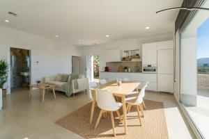 a kitchen and dining room with a table and chairs at Villa Las Palmeras Valdevaqueros Suites, Pool & Sea Views in Tarifa