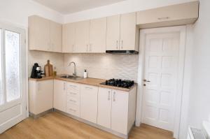 a kitchen with white cabinets and a white door at Zen Retreat House Sovata in Sovata