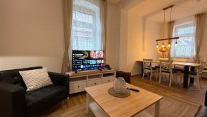 a living room with a couch and a tv and a table at Ferienhaus Anna in Winsen
