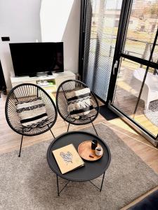 a living room with two chairs and a table at Wczasowy Loft Sominy in Sominy