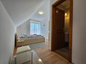 a small bedroom with a bed and a window at Csenár Apartman Hegykő in Hegykő +5 photos
