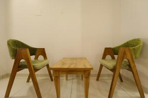 two chairs and a wooden table in a room at Nova Yashraj Hotel in Rajkot