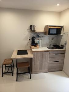 a small kitchen with a sink and a microwave at Le torii in Cilaos