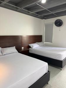 two beds in a hotel room with two beds sidx sidx sidx at Hotel Provenza Suites in Ocaña