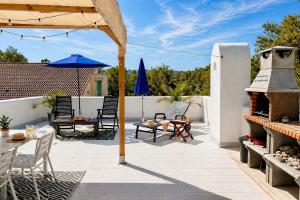 a patio with tables and chairs and an umbrella at Hauzify I Casa Olivella B in Olivella +12 photos
