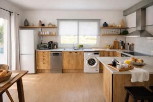 a kitchen with wooden cabinets and a white refrigerator at Hauzify I Casa Olivella B in Olivella