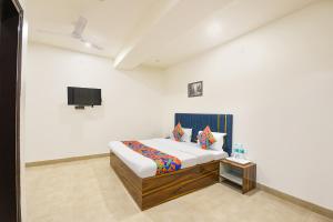 a bedroom with a bed and a tv on the wall at FabHotel The Fortune in New Delhi