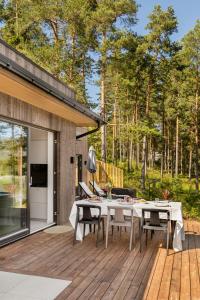 a patio with a table and chairs on a wooden deck at Modern Cabin With Panoramic Views in Hønefoss