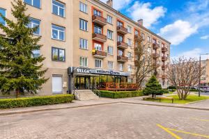 an apartment building with a sign for a hotel at Velga in Vilnius