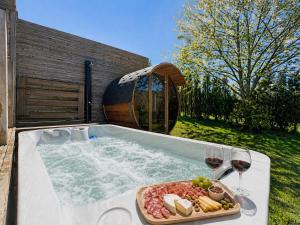 ein Whirlpool mit einem Tablett mit Speisen und Weingläsern in der Unterkunft Chaly in Stoumont + 22 Fotos