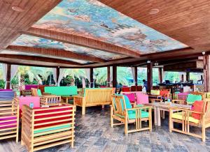 a restaurant with colorful chairs and tables and a mural at Dreamland Aparts in Chakvi