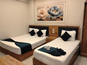 two beds in a room with a painting on the wall at Up Town Crown Hotel in Cairo +26 photos