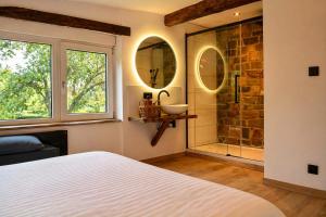 ein Schlafzimmer mit einem Badezimmer mit Waschbecken und Dusche in der Unterkunft Chaly in Stoumont