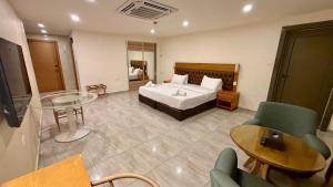 a hotel room with a bed and a table and chairs at Jawheret S Hotel Suite in Amman