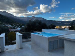 a swimming pool on top of a building with mountains at Karen's Favorite in Skala Potamias