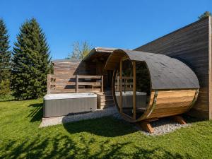 ein großes hölzernes Hobbit-Haus mit rundem Dach in der Unterkunft Chaly in Stoumont