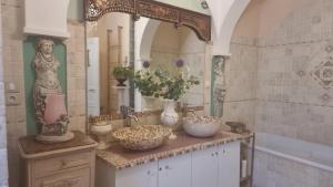 a bathroom with a counter with bowls and vases on it at Clos Germanois entre Clermont, Lyon ,St Etienne A89 sortie 32 in Saint-Germain-Laval +66 photos
