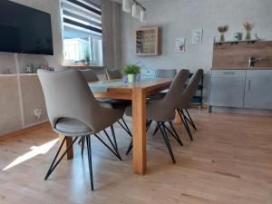 a dining room with a wooden table and chairs at Haus Schwalbennest in Dahme