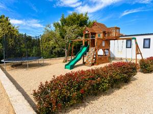 a playground with a slide and a swing at Aurea Lux in Pakoštane