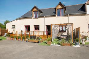 a house with a fence and potted plants in front of it at Gîte Les Légendes du Plessis in Iffendic