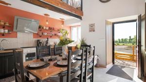 a kitchen with a wooden table and a dining room at Gîte Les Légendes du Plessis in Iffendic