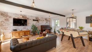 a living room with a couch and a pool table at Gîte Les Légendes du Plessis in Iffendic