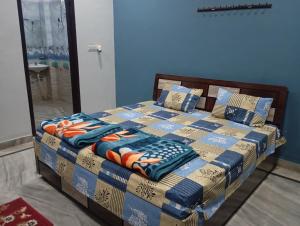 a bed in a bedroom with a blue wall at DEV PALACE Hotel & Hostel in Palāi +3 photos