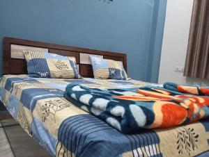 a bed with a blanket and pillows on it at DEV PALACE Hotel & Hostel in Palāi