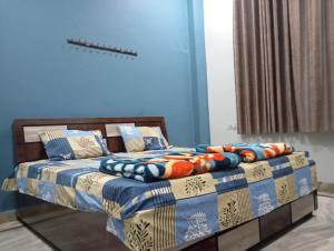 a bedroom with a bed with a blue wall at DEV PALACE Hotel & Hostel in Palāi