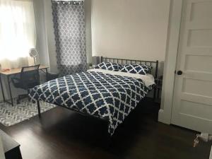 a bedroom with a bed with a black and white comforter at Homestay in Boston Fields Corner Area in Boston