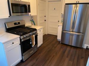 a kitchen with a stove and a stainless steel refrigerator at Homestay in Boston Fields Corner Area in Boston