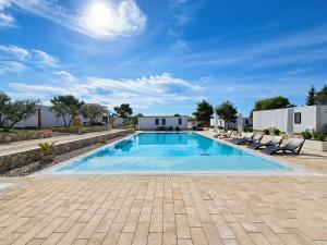 a swimming pool with lounge chairs in a yard at Aurea Lux in Pakoštane