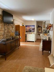 a living room with a tv on a stone wall at Artisana Silba in Silba
