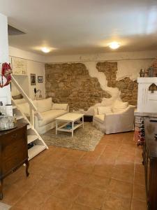a living room with couches and a stone wall at Artisana Silba in Silba