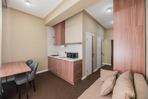 a living room with a couch and a table and a kitchen at UIDE Apart hotel in Almaty +49 photos