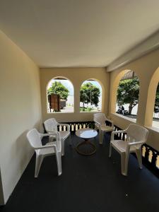 a waiting room with chairs and tables and windows at Oakeland By Grovien in Ponnāni +8 photos