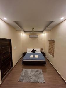 a bedroom with a bed and a door and a rug at Oakeland By Grovien in Ponnāni